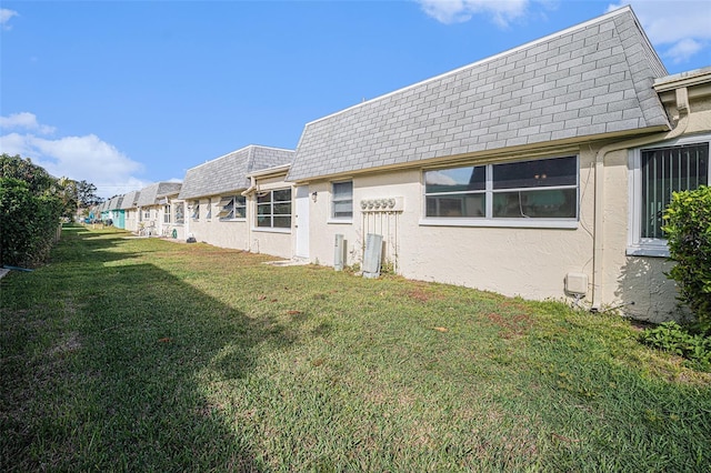 rear view of property featuring a lawn