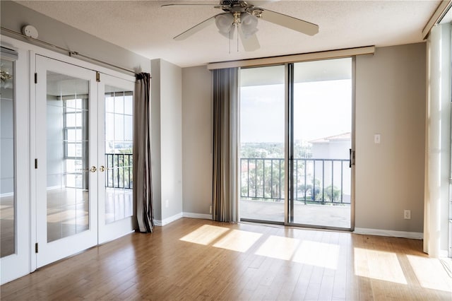 doorway to outside featuring ceiling fan, light hardwood / wood-style flooring, a textured ceiling, and french doors