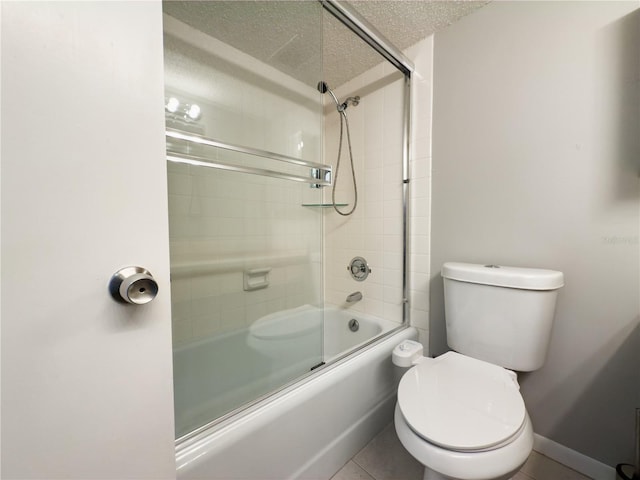 bathroom featuring tile patterned floors, bath / shower combo with glass door, a textured ceiling, and toilet