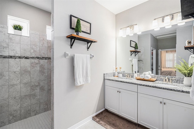 full bathroom featuring a walk in shower, double vanity, a sink, and ensuite bathroom