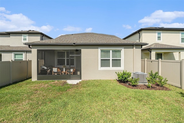 rear view of property with a lawn, a sunroom, and cooling unit