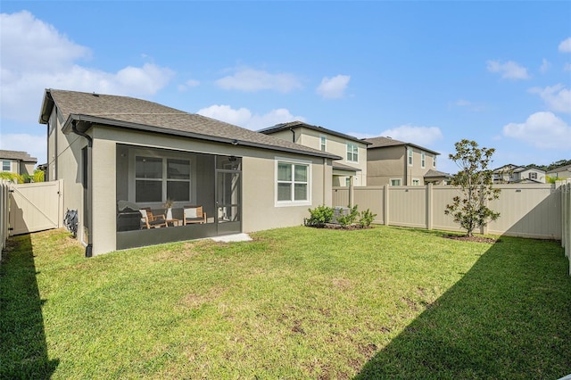 rear view of property featuring a lawn and a sunroom