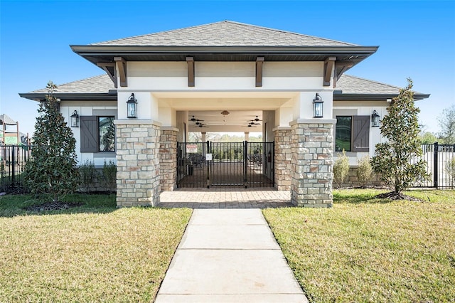 entrance to property with roof with shingles, a yard, stucco siding, fence, and stone siding