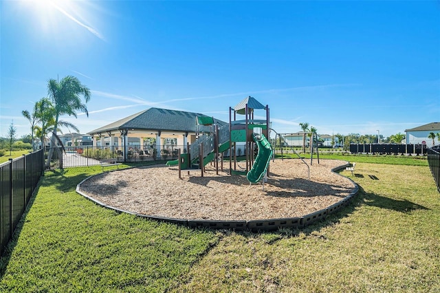 community play area featuring fence and a lawn