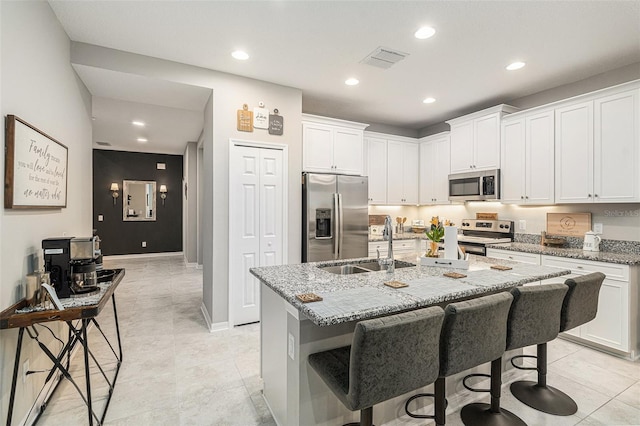 kitchen with a sink, visible vents, appliances with stainless steel finishes, and a breakfast bar area