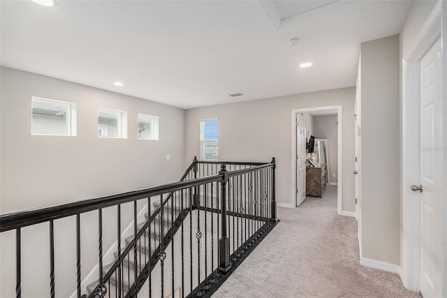 hallway with an upstairs landing, recessed lighting, baseboards, and light colored carpet