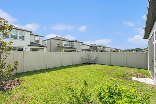 view of yard with a fenced backyard and a residential view