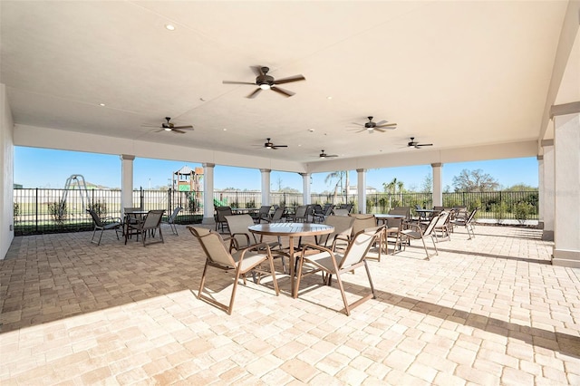 view of patio featuring outdoor dining area, fence, and ceiling fan