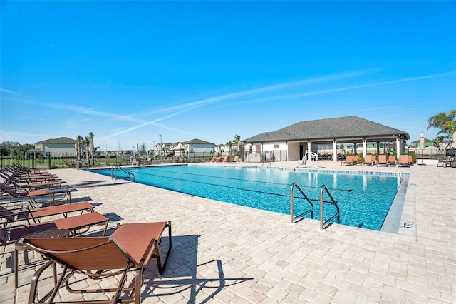 community pool featuring a patio and fence