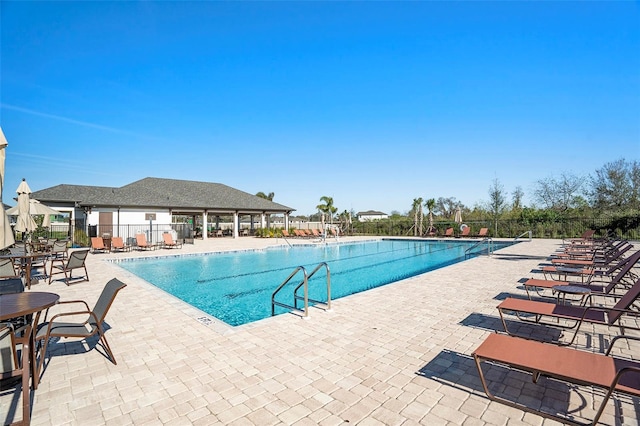 community pool featuring a patio and fence