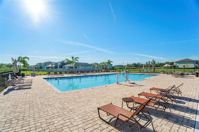 community pool featuring a patio area and fence