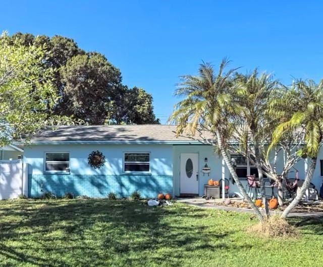 rear view of property featuring a lawn