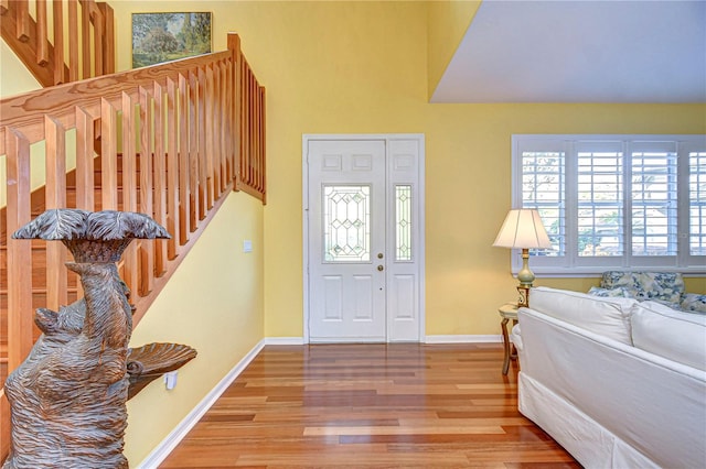 foyer with a towering ceiling and hardwood / wood-style flooring