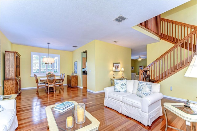 living room with hardwood / wood-style flooring and ceiling fan