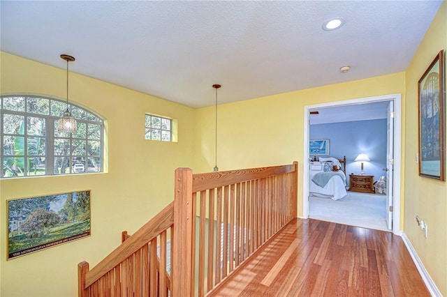 hall featuring hardwood / wood-style floors and a chandelier