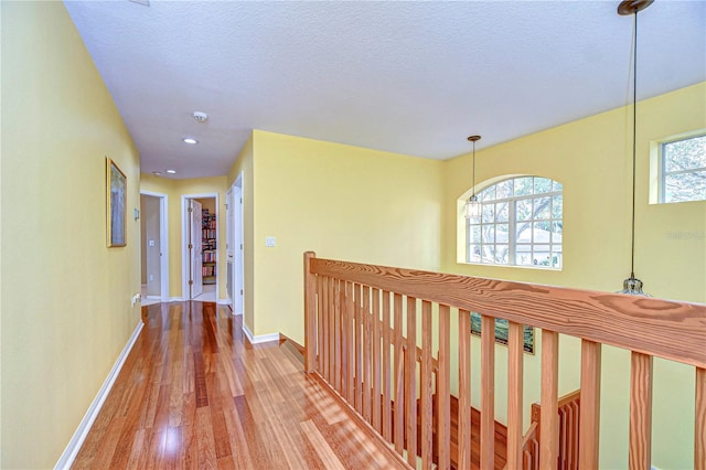 hall featuring hardwood / wood-style floors and a textured ceiling