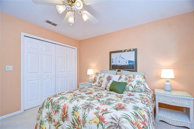 bedroom with ceiling fan, light colored carpet, and a closet