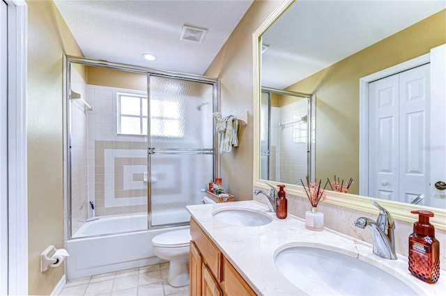 full bathroom featuring tile patterned floors, shower / bath combination with glass door, vanity, and toilet