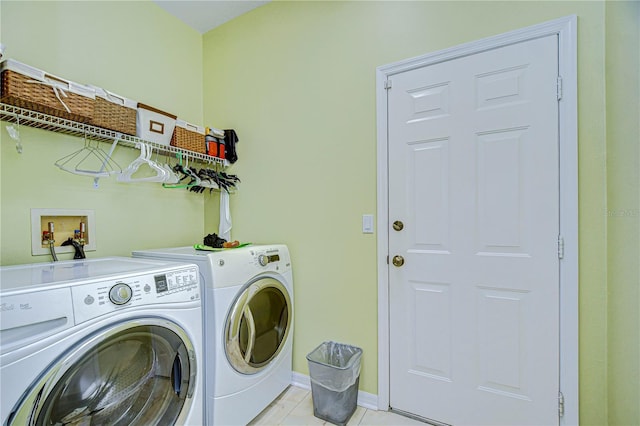 clothes washing area featuring light tile patterned floors and separate washer and dryer