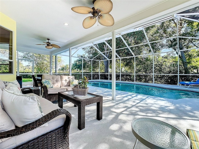 view of pool with an outdoor living space, ceiling fan, a patio, and glass enclosure