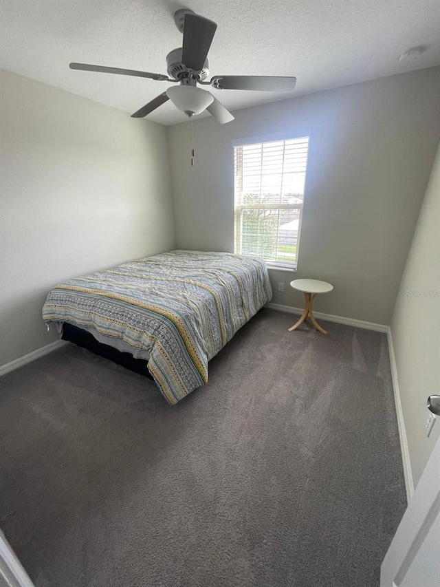 bedroom with carpet, ceiling fan, and a textured ceiling