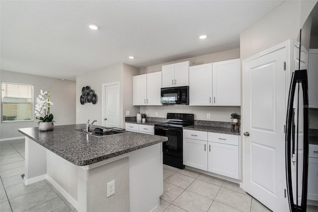 kitchen featuring white cabinetry, sink, a center island with sink, and black appliances