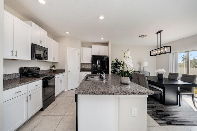 kitchen with white cabinetry, black appliances, and a kitchen island with sink