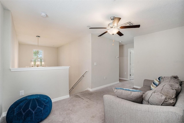 living area featuring ceiling fan with notable chandelier, a textured ceiling, and carpet flooring