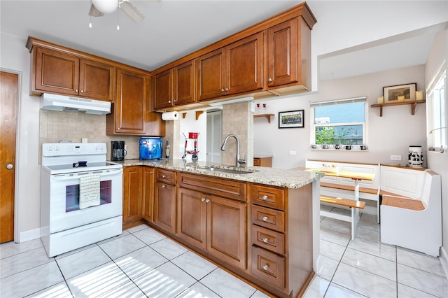 kitchen featuring sink, decorative backsplash, light tile patterned floors, white range with electric stovetop, and kitchen peninsula