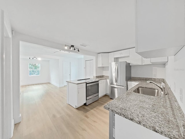 kitchen featuring sink, stainless steel appliances, light hardwood / wood-style flooring, kitchen peninsula, and white cabinets