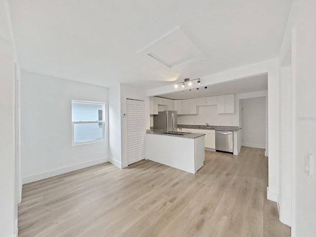 kitchen with sink, light wood-type flooring, white cabinetry, kitchen peninsula, and stainless steel appliances