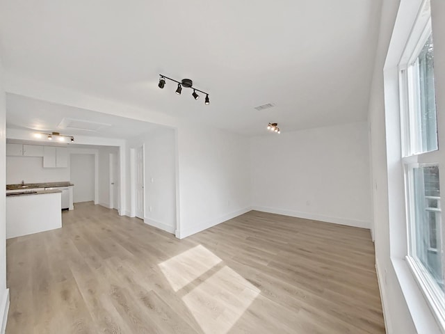 unfurnished living room featuring a healthy amount of sunlight and light hardwood / wood-style flooring