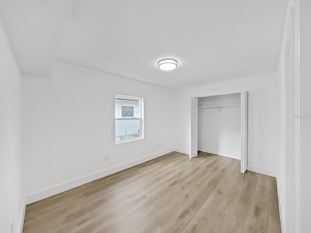 unfurnished bedroom featuring light hardwood / wood-style floors and a closet