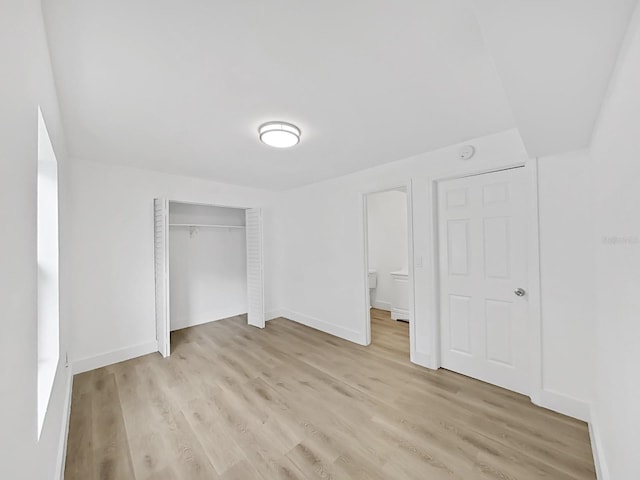 unfurnished bedroom featuring light hardwood / wood-style flooring and a closet