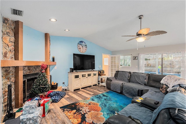 living room with ceiling fan, a fireplace, wood-type flooring, and vaulted ceiling