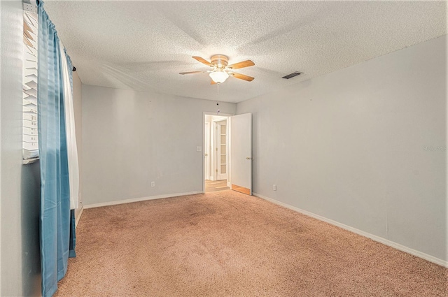 carpeted spare room featuring ceiling fan and a textured ceiling