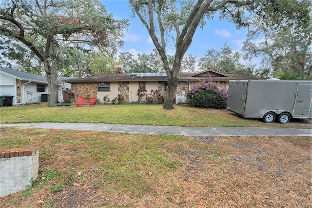 ranch-style home featuring solar panels and a front lawn