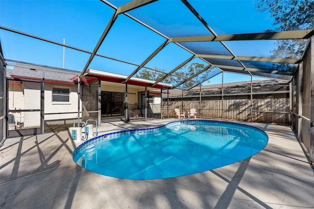 view of swimming pool featuring a patio and glass enclosure