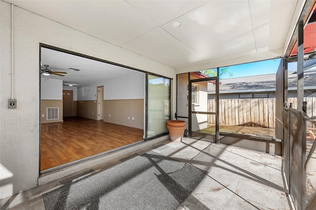 unfurnished sunroom with ceiling fan