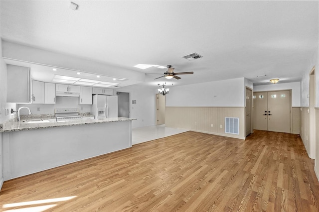 kitchen with stove, light wood-type flooring, sink, white cabinets, and white fridge with ice dispenser