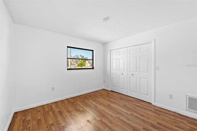 unfurnished bedroom with a closet and hardwood / wood-style floors