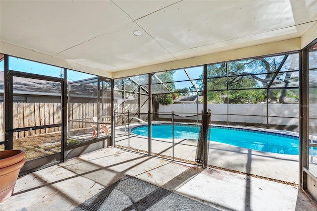 view of swimming pool featuring glass enclosure and a patio