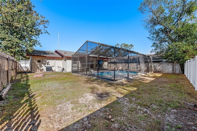 view of yard with a lanai, a fenced in pool, and central AC