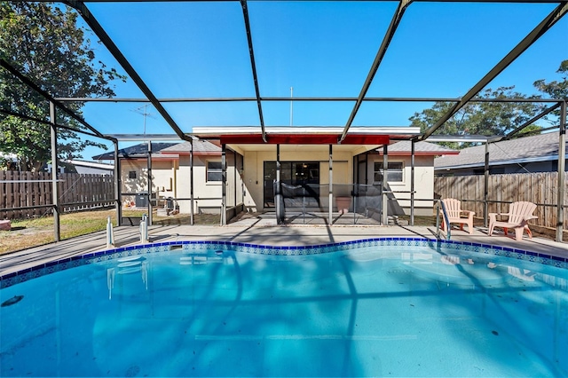 view of swimming pool featuring glass enclosure and a patio area