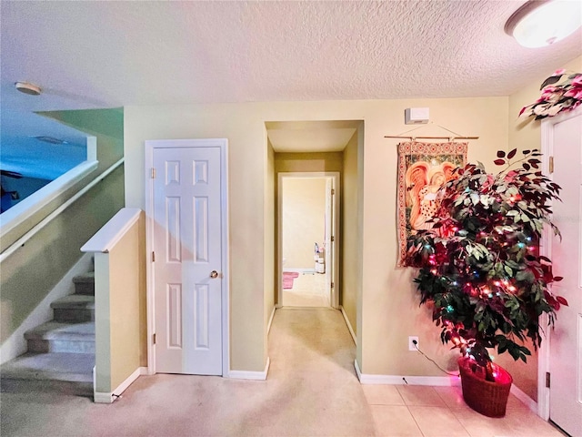 corridor featuring tile patterned floors and a textured ceiling