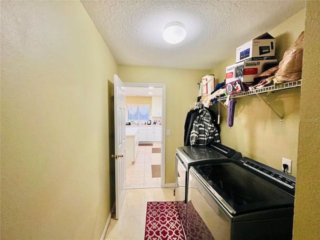 clothes washing area featuring a textured ceiling, light tile patterned floors, and independent washer and dryer