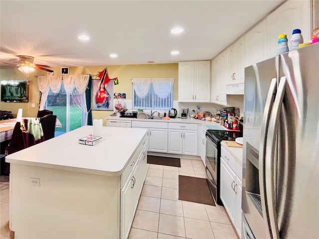 kitchen featuring white cabinets, a kitchen island, black range with electric stovetop, sink, and stainless steel fridge