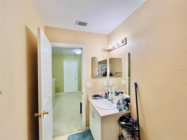 bathroom featuring a textured ceiling and vanity