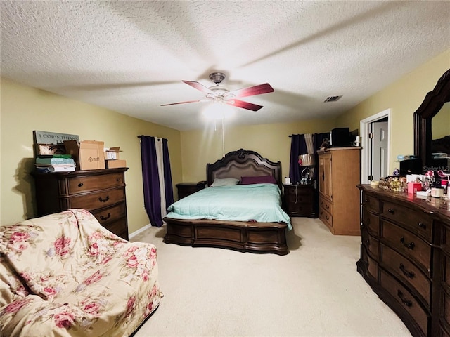 bedroom featuring ceiling fan, a textured ceiling, and light carpet