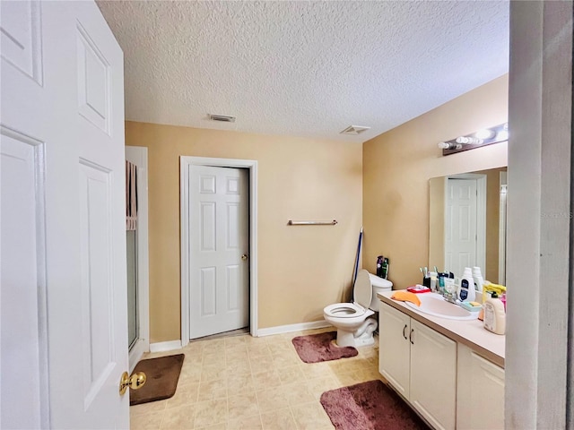 bathroom with toilet, a textured ceiling, walk in shower, and vanity